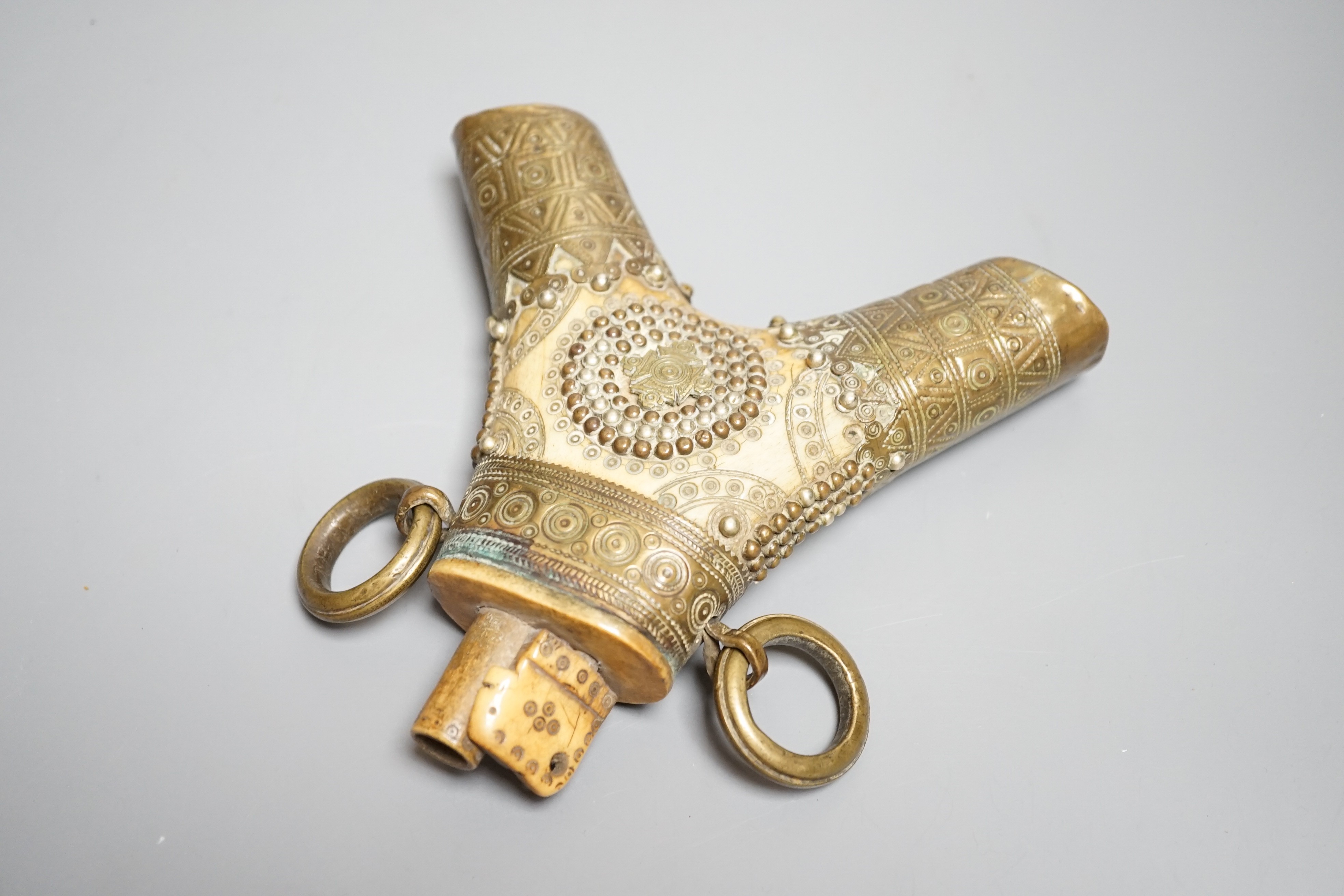 A Transylvanian staghorn powder flask 18th century, geometric decoration to body and brass mounts with central Teutonic order emblem. Maximum 16cms